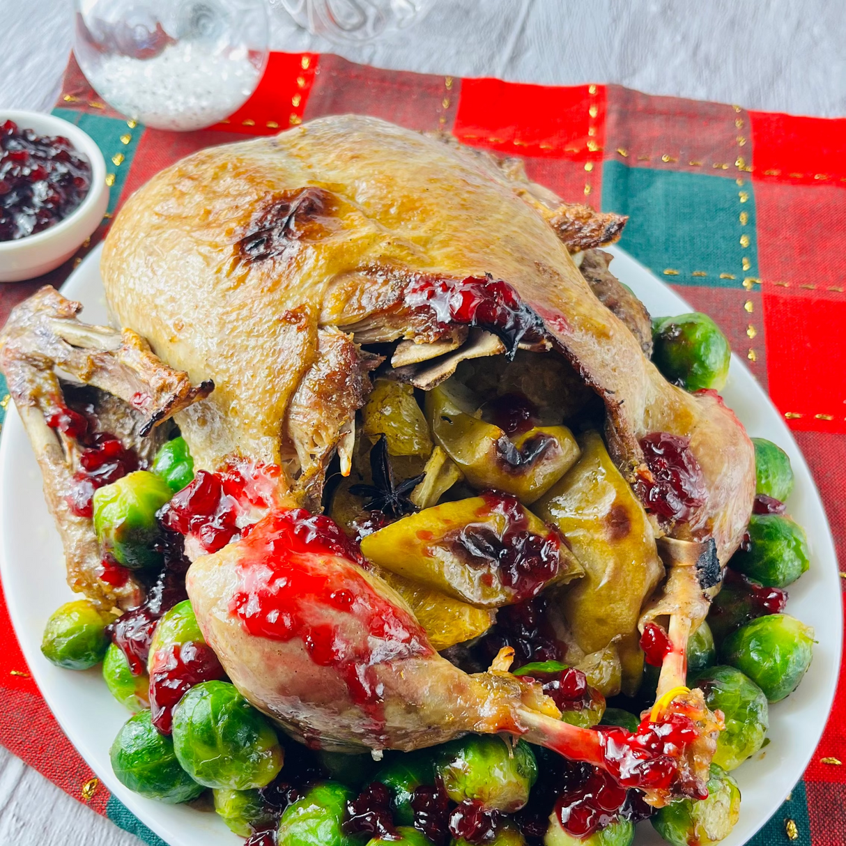 Утка, фаршированная яблоками с пряными специями, с брюссельской капустой и соусом из красной смородины