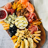 Красивая большая винная тарелка с запечённым камамбером, мандаринами и хамоном